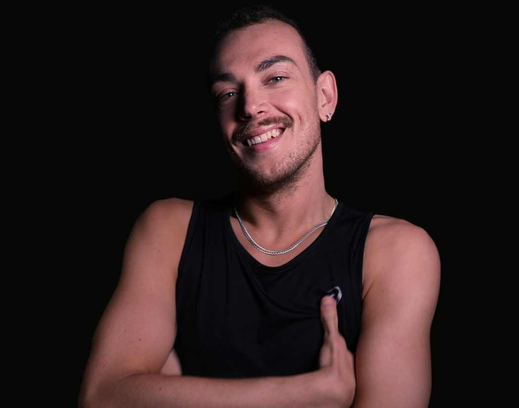 Psycle coach Callum wearing a black tank top against a black background